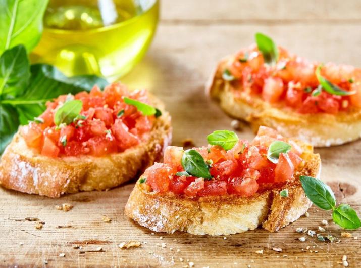 Bruschetta with fresh tomatoes and basil on a wooden board.