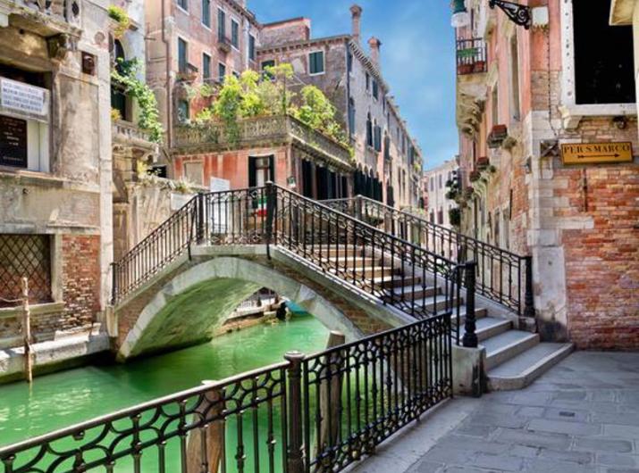 Pont sur un canal vénitien avec des bâtiments historiques.