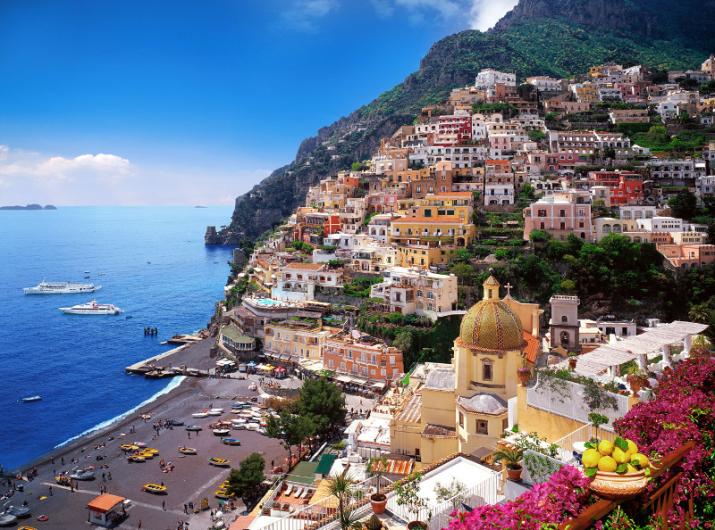 Vue panoramique de Positano, maisons colorées et mer cristalline.