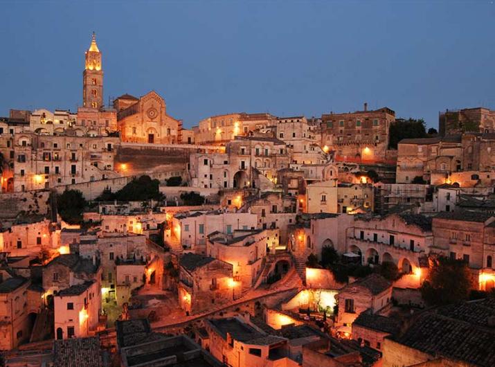 Vista noturna de Matera com luzes quentes.