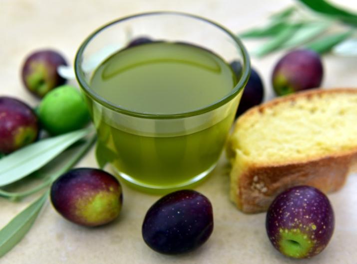 Olive oil with olives and bread.