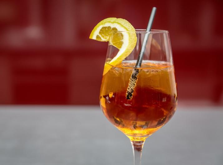 Spritz glass with lemon slice and straw.